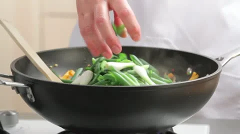 Mixing spring onions with other vegetables in a wok Video stock 24665110