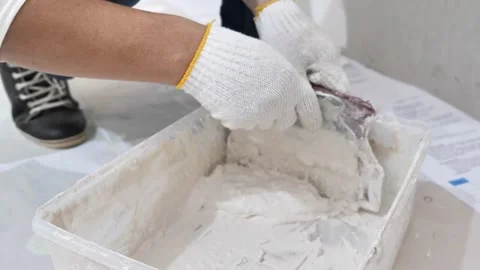 Mixing stir wall putty of cement or gypsum for wall painting preparation Stock Footage 260670533