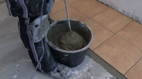 Mixing tile adhesive or cement with power drill tool Stock Footage 42591912