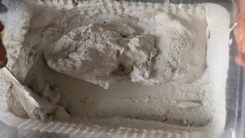 Mixing tile adhesive with putty knife in plastic container for construction.. Stock-Footage 295931630