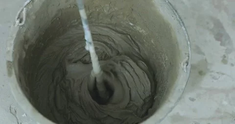Mixing tile mortar for laying ceramic tiles or porcelain tiles. A man kneads Stock Footage 313727635