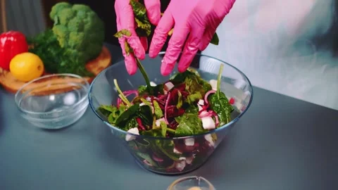 Mixing vegetable salad with hands in the kitchen Stock-Footage 252180761