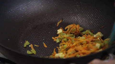 Mixing vegetables in a wok Stock Footage 143892771