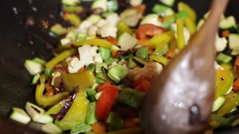 Mixing the vegetables in the wok with the spoon Stock-Footage 131973565