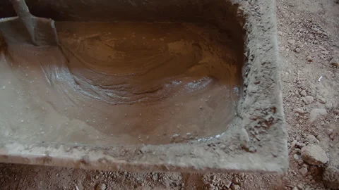 Mixing wet cement with shovel in rectangular container Stock Footage 311124171