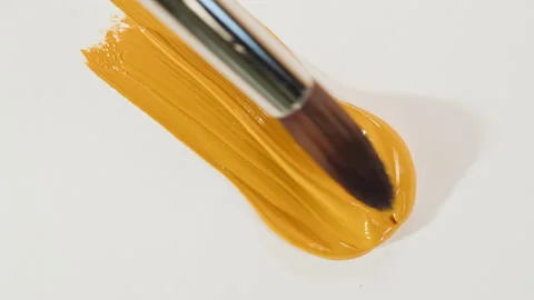 Mixing yellow paint close-up. Drawing on white paper top view. Smearing guache Stock Footage 178614927
