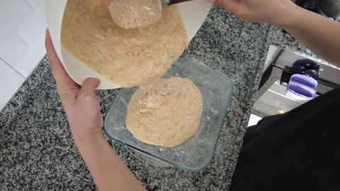 The mixture containing ingredients are poured into the baking dish. Stock Footage 234785830