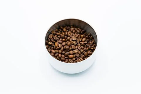 Mixture of different kinds of roasted coffee beans in white container on whit Foto stock