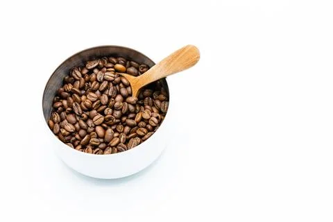Mixture of different kinds of roasted coffee beans with wooden spoon in white Foto stock