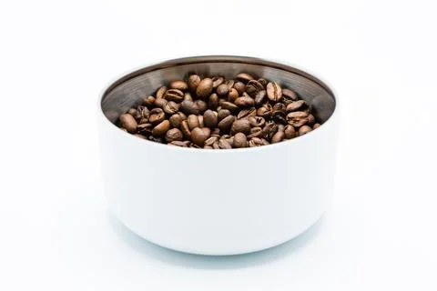 Mixture of different kinds of roasted coffee beans in white container on whit Foto stock
