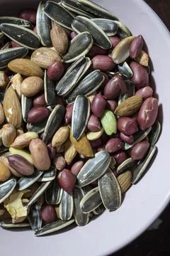 A mixture of different types of nuts and seeds. Ground nuts, almonds, seeds. Stock Photos