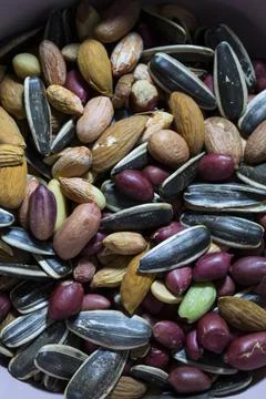 A mixture of different types of nuts and seeds. Ground nuts, almonds, seeds. Stock Photos