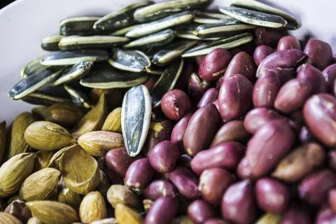 A mixture of different types of nuts and seeds. Ground nuts, almonds, seeds. Stock Photos