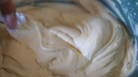 The mixture of flour and eggs to make the bread is stirred Video stock 305415992