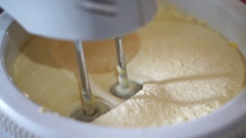 Mixture of flour and eggs to make the bread is stirred with an electric mixer Video stock 305416022