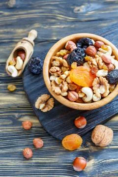 Mixture of nuts and dried fruit in a wooden bowl. Stock Photos