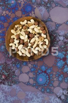 A Mixture Of Nuts (Cashews, Walnuts, Hazelnuts) On A Wooden Plate