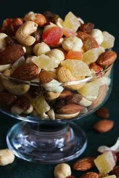 Mixture of peeled kernels of nuts and dried fruits in a glass vase. Stock Photos