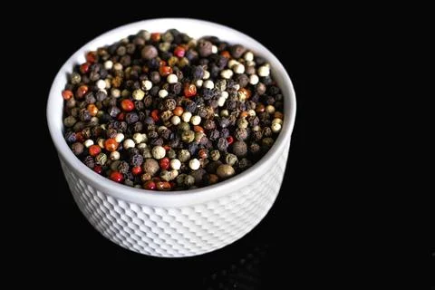 A mixture of pepper varieties with peas on the white plate Foto stock