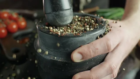 A mixture of peppers ground in a stone mortar, cooking in slow motion 動画素材 105418094