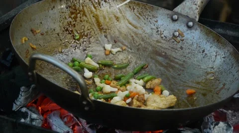 A mixture of vegetables is fried in a large frying pan at the stake Stock Footage 68209634