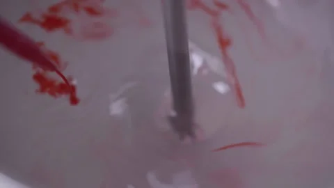 Mixture of viscous liquid with red dye, dyeing process Stock Footage 340282901