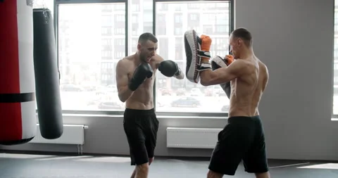 MMA fighter is practising his strikes with trainer in slow motion in the gym Stock Footage 161128044