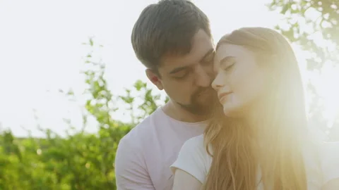 Mman hugging from back his girlfriend, woman putting head on boyfriend's Stock Footage 253560184