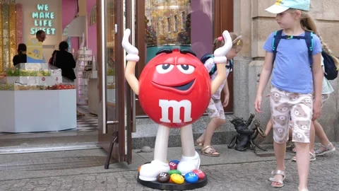 Mms candy small statue on a city street by the entrance to a sweets shop Vídeos de archivo 281969262