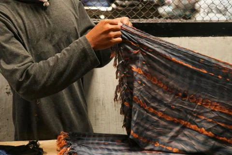 Mn hands folded the fabrics in tailor's workshop. Folded squared pattern saru Stock Photos