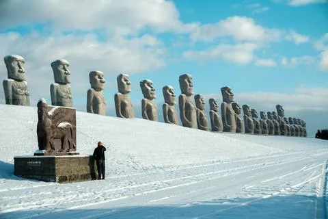 Moai, big stone statue in winter with snow on ground at hill of Buddha Stock Photos