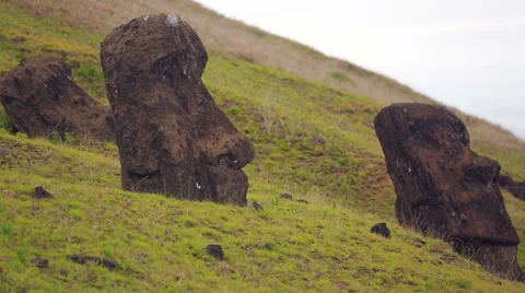 Moai Statues half burried on the hillside of a mountain on Easter Island Stock Footage 64258479