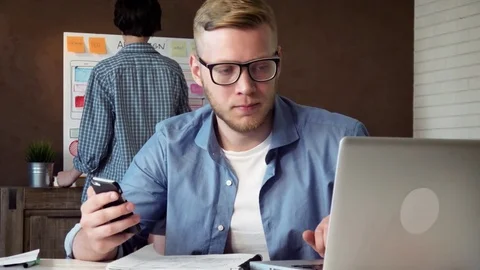 Mobile app developer comparing mobile and web versions of his design concept Vídeos de archivo 79661176