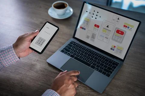 Mobile app interface concept with designer using smartphone and laptop, sho.. Stock Photos