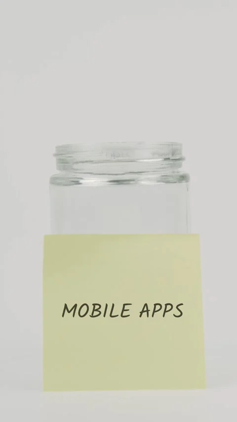 Mobile apps text or word on yellow sticky note attached to glass jar Stock Footage 311755842