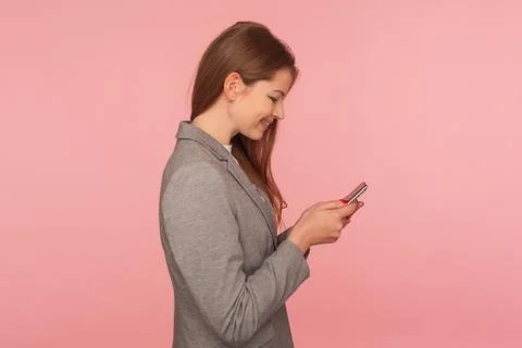 Mobile business application. Side view of satisfied elegant lady boss in suit Stock-Fotos
