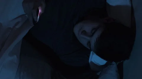 Mobile cheating sneaky husband phone bed vertical Stock Footage 198921751