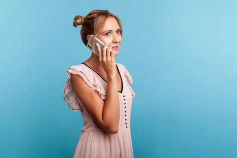 Mobile communication. Side view of good looking young adult woman in dress ca Foto stock