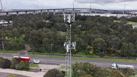Mobile communication tower with cityscape and highway traffic Video stock 342325945