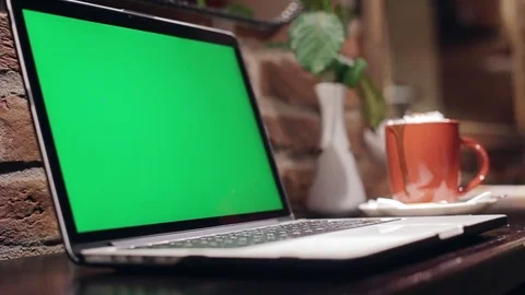Mobile computer is standing on a wooden table in internet cafe. Green screen Stock Footage 84954558