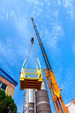 Mobile crane with hook and straps is raising work platform, basket Stock Photos