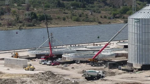 Mobile crane lifting metal structure at silo construction site Stock Footage 345928213