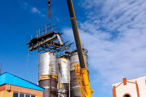Mobile crane lowering part of a big old metal truss Stock Photos