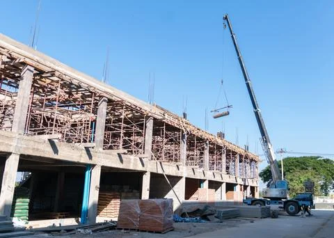 A mobile crane operating at a large construction site. Stock Photos