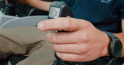 A mobile crane operator's hand holding a joystick to control a crane mechanism. Video stock 138078949