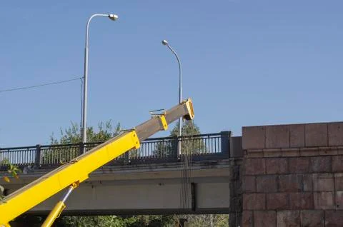 A mobile crane performs cargo work on a road bridge. Stock Photos