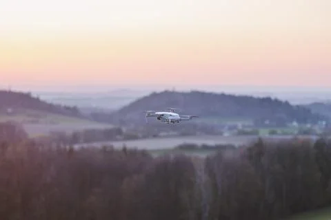 Mobile drone at work during sunset. Technological innovation in photography a Stock Photos
