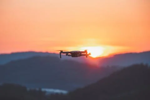 Mobile drone at work during sunset. Technological innovation in photography a Stock Photos
