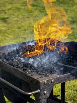 Mobile forge with fire and iron bar Stock Photos
