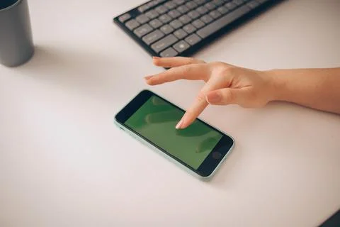 Mobile with a green screen, the smartphone is on the table near the clarifier Stock Photos